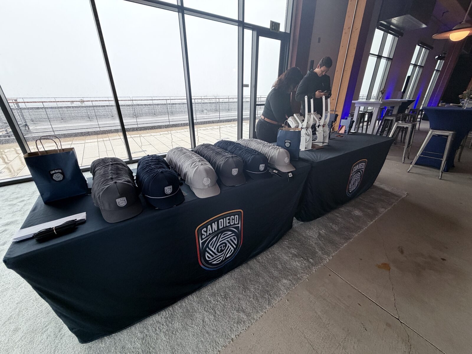 Finished custom caps displayed on a merch table at a corporate event